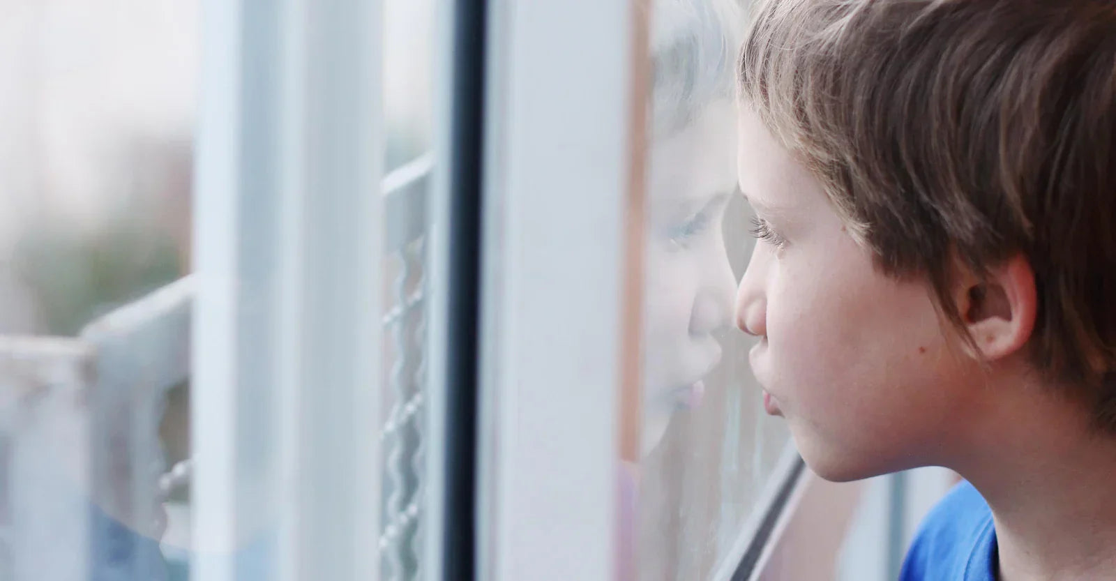 boy looking out of window 
