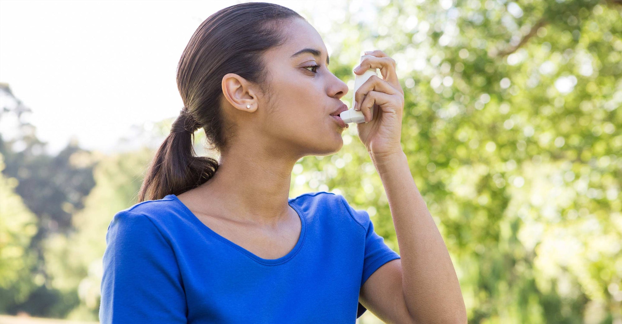 Woman with asthma using inhaler