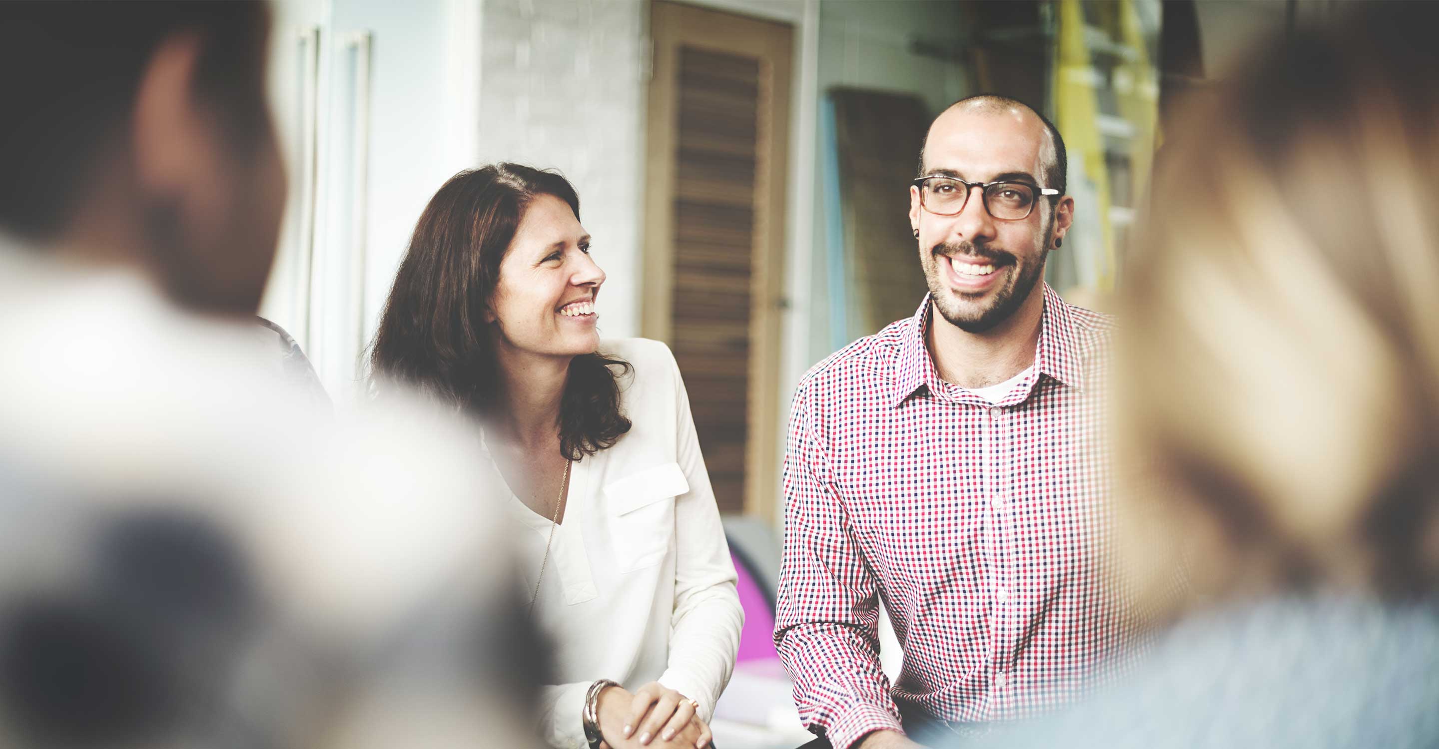 Woman smiles at man talking to community coalition