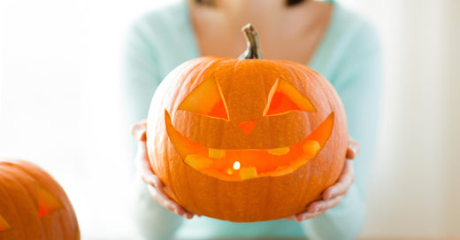 woman holding carved pumpkin in hands