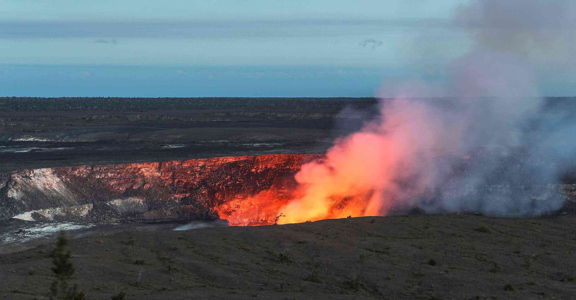 Hot lava glow of its active vent, spewing out smoke as the molten rock burns