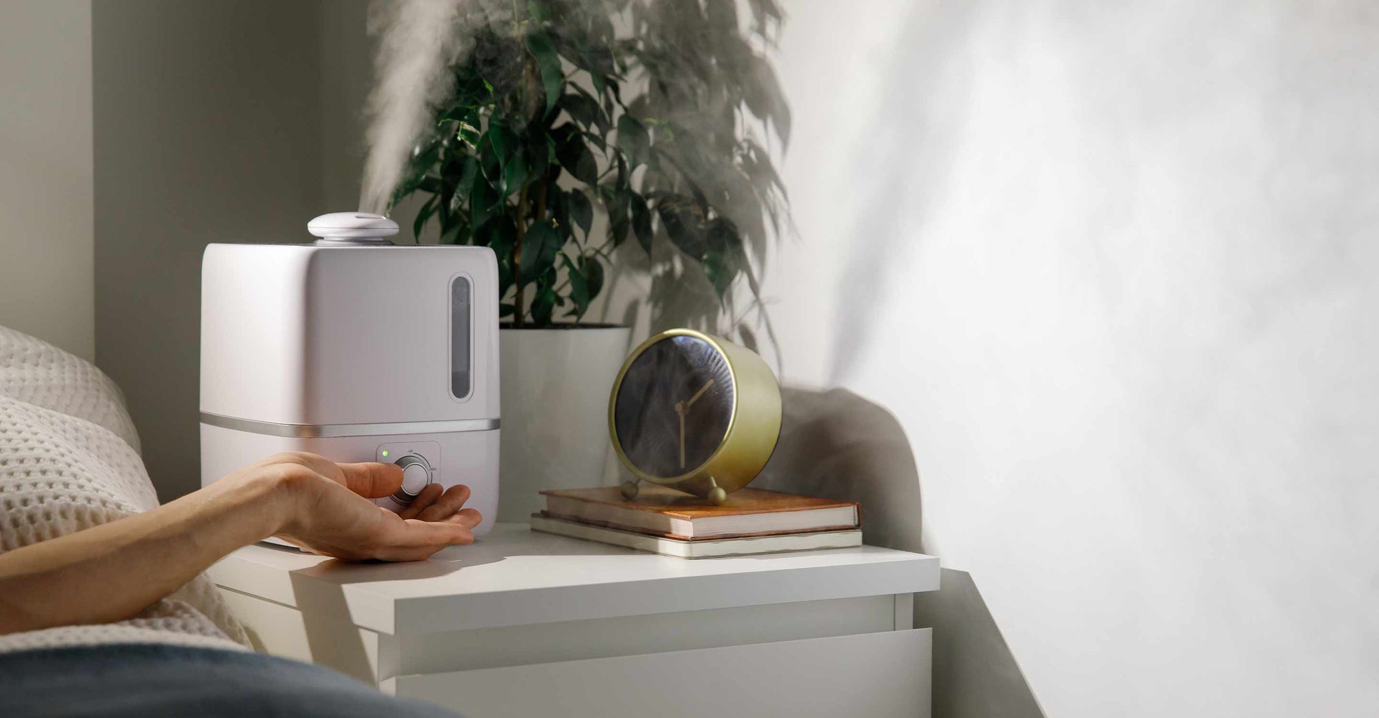 Hand reaching for humidifier on night stand